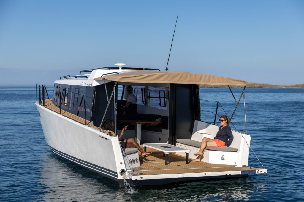 Le Nomad 40 vu de l'arrière au mouillage, avec le taux déployé sur la plage arrière pour donner de l'ombre à l'équipage