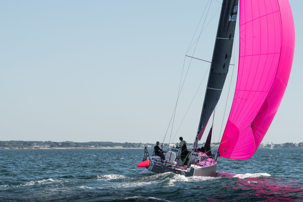 Vue arrière du JPK 1050 sous spinnaker asymétrique en rade de Lorient, dans un vent medium faible. On voit que le bateau est déjà proche du planning.